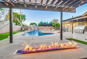 A backyard with a swimming pool, a fire feature, and a barbecue area. - Salt Water Pool & Mini Golf - Close to Downtown (Bonita)