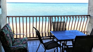 En balkong med utsikt över havet, ett bord och en soffa.