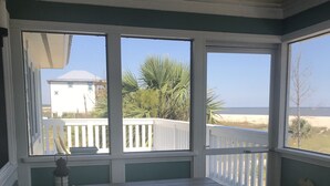 A room with a white table and bench, large windows with a view of a beach and a white fence. - Fantastic Beach views, Great house & just steps until your feet are in the sand! (Indian Pass)