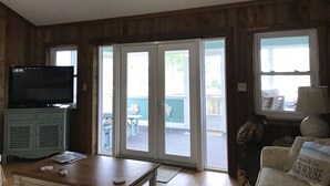 A living room with a television, a wooden cabinet, a table, and a couch. - Fantastic Beach views, Great house & just steps until your feet are in the sand! (Indian Pass)