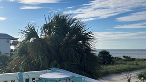 A deck with a table and chairs, overlooking a beach and ocean. - Fantastic Beach views, Great house & just steps until your feet are in the sand! (Indian Pass)