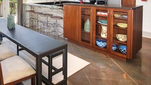 Une cuisine moderne avec des meubles en bois, un îlot central doté de tabourets et une table à manger avec des chaises.