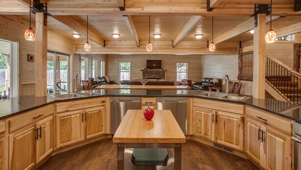 A spacious kitchen with wooden cabinets, a central island, and pendant lighting. - Home Theater, Hot tub & Huge Covered Patio! Stunning Home 2 Miles from Town! (Leavenworth)