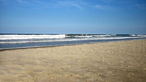 A beach with a clear sky and waves.