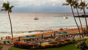 Un complexe hôtelier de bord de mer doté d’une piscine, de palmiers et offrant une vue sur l’océan.