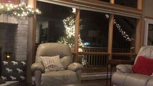 Una sala de estar acogedora con chimenea, un ventanal con vistas y una zona de estar confortable.