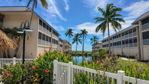 A resort with multiple-story buildings, a pool, and tropical landscaping.