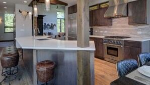 Una cucina moderna con isola centrale, elettrodomestici in acciaio inossidabile e un'ampia finestra.