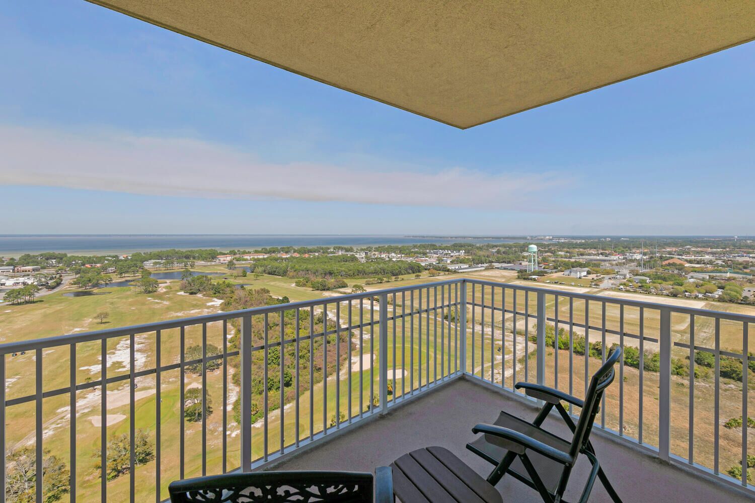 Ein Balkon mit Blick auf einen Golfplatz und einen Wasserturm.