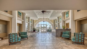 A spacious lobby with high ceilings, large windows, and a central seating area with green upholstered chairs. - Ariel Dunes II2306 - 23rd Floor, Breathtaking Views, Accommodates up to 6! (Miramar Beach)