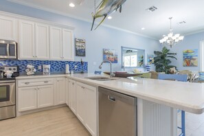 A modern kitchen with white cabinets, a stainless steel microwave, and a dishwasher.