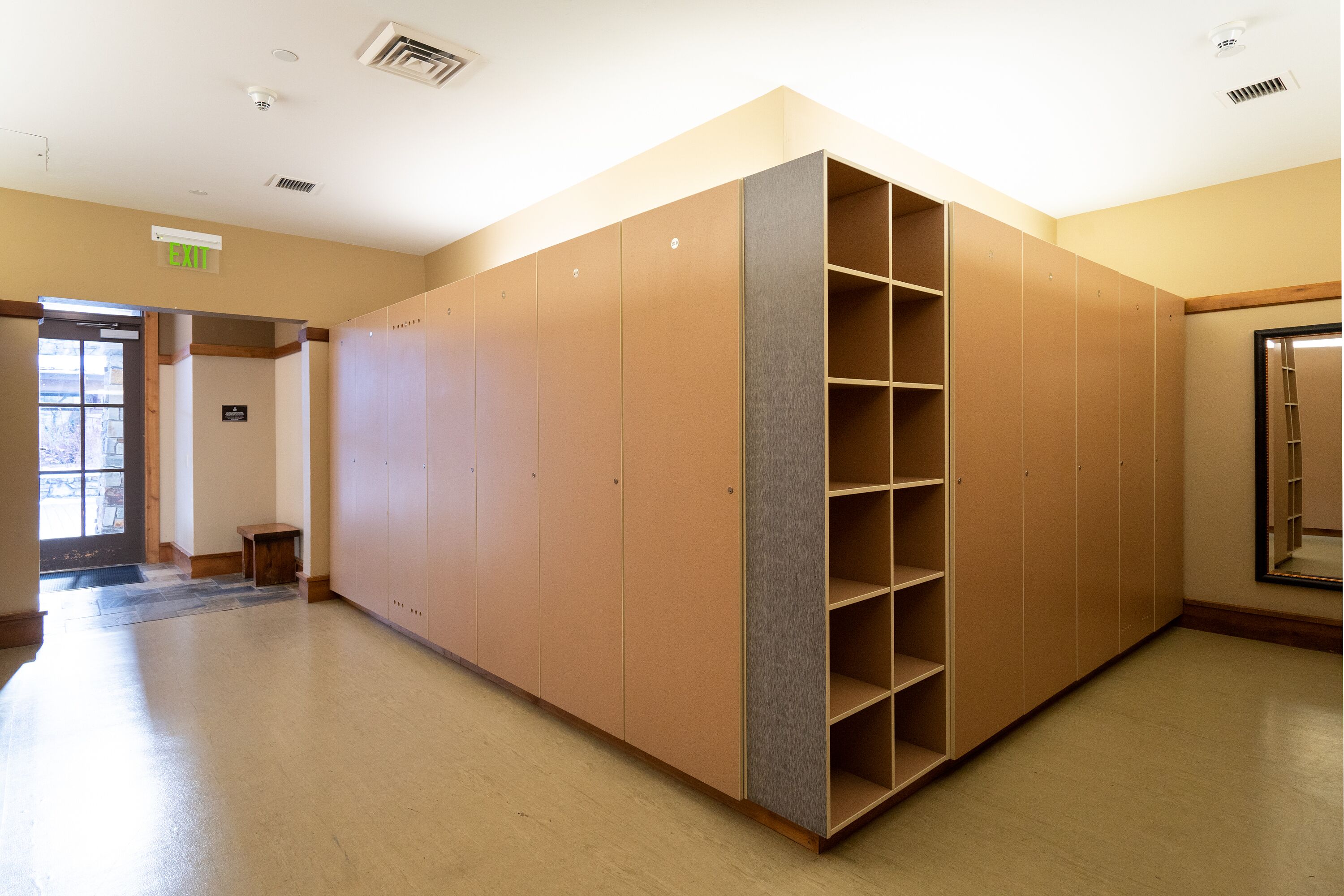 A spacious room with a large wardrobe, a door leading outside, and a small table.