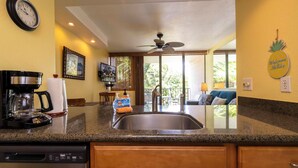 A kitchen with a coffee maker, sink, and wooden cabinets.