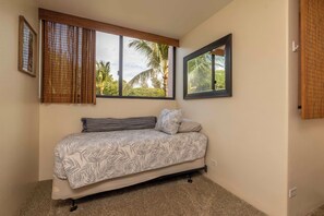 A bedroom with a bed, two windows, and a view of palm trees. - Kealia 407 Partial Ocean View Comfortable Charming Paradise Unit Washer/Dryer (Kihei)