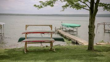 Un quai avec des canoës et un arbre au premier plan.