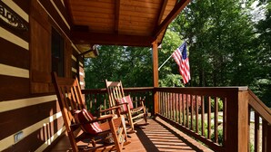 Eine Veranda mit Schaukelstühlen und einer amerikanischen Flagge.