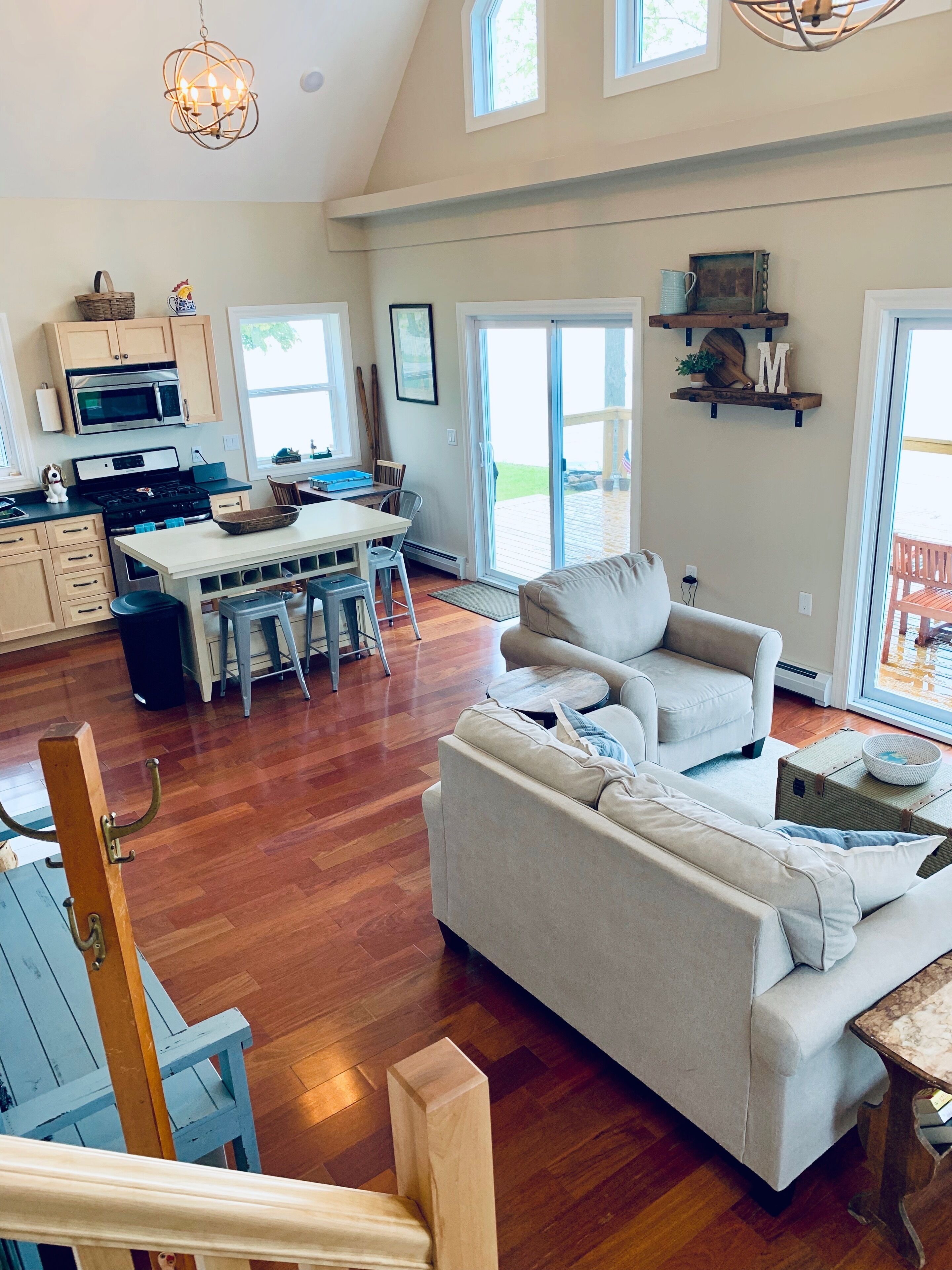 A spacious living area with a large sofa, a dining table, and a kitchen area with a microwave and stove.