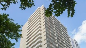 Ein Hochhaus mit einem Schild für 'Marine Surf Waikiki' im unteren Bereich.