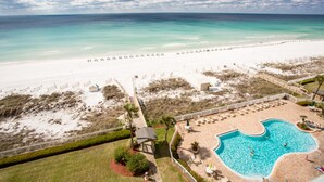 En vy från ovan över ett strandhotell med en swimmingpool, direkt tillgång till stranden och utsikt över havet.