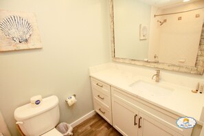 Une salle de bain avec des toilettes, un lavabo et un miroir.