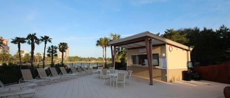 Una terraza en la azotea con sillones de descanso y una pequeña barra.