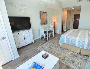 Une chambre d’hôtel avec un lit, un bureau, une télévision et un miroir.