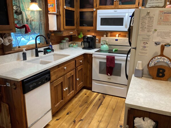 A kitchen with wooden cabinets, a microwave, a stove, and a dishwasher.