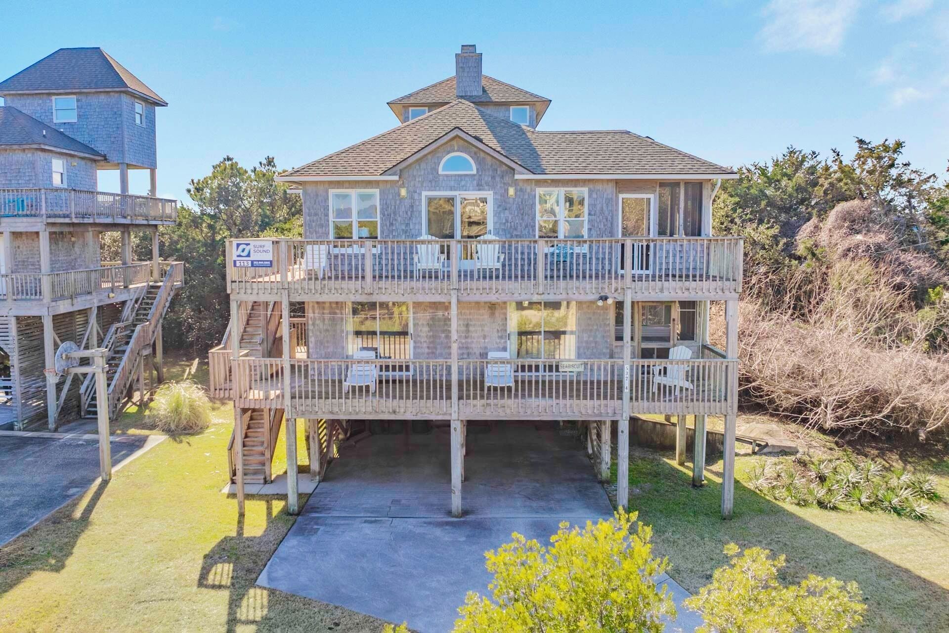 A two-story wooden building with balconies, a covered deck, and a staircase.