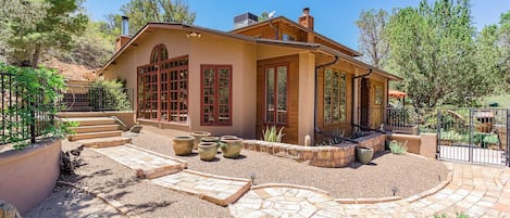 A house with a patio, large windows, and a garden.