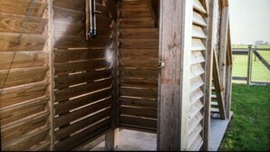 Una escalera de madera que conduce a un altillo con barandilla metálica y una ventana.