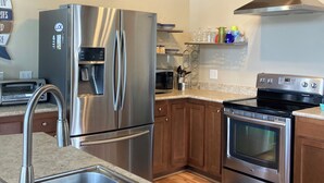 A modern kitchen with stainless steel appliances, a wooden ceiling, and a built-in oven. -  Lake Front Home with community boat ramp. Private,  close to marinas and town. (Somerset)