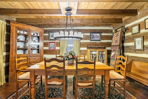 A wooden dining room with a large table, chairs, and a cabinet with dishes. - DOGWOOD LODGE • TIMBERIDGE (SPARED)• (Gatlinburg)