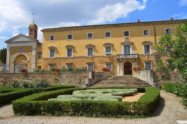 A historic building with a central entrance, a bell tower, and a symmetrical facade.
