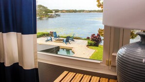 A view of a lake with boats, a patio with chairs, and a swimming pool. - Lakefront Pool Home w/ Game Room, Epic View, Kayaking (Tampa)