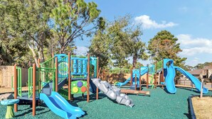 Ein Spielplatz mit mehreren Rutschen und Klettergerüsten.
