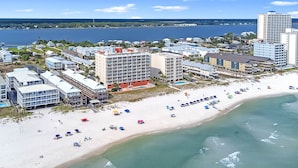 Een kusthotel met meerdere gebouwen, een zandstrand en uitzicht op zee.