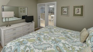 Une chambre à coucher avec un lit, une commode, un téléviseur et une porte équipée de stores.