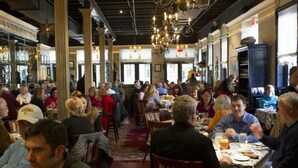 A crowded restaurant with high ceilings, chandeliers, and large windows. - 1 Bedroom Cottage in the Old Historic District. Free Street Parking.  (Charleston)