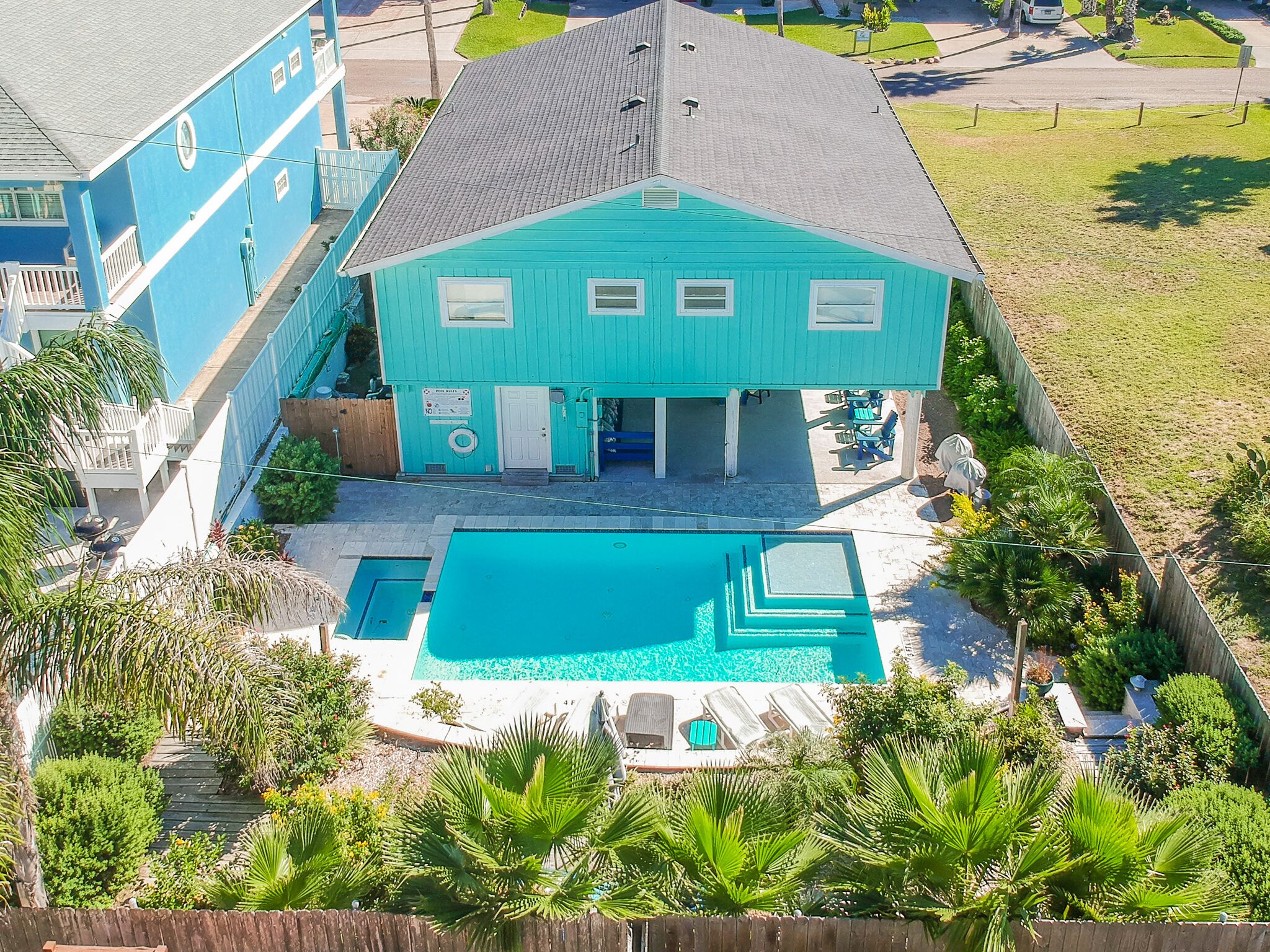 Ein zweistöckiges Haus mit Swimmingpool, umzäunter Garten und einer kleinen Terrasse.