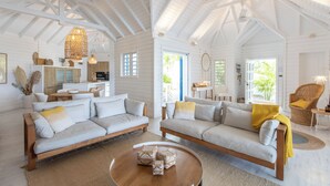 A spacious living area with two sofas, a coffee table, and a dining table. - A dream villa for an unforgettable holiday! (SAINT MARTIN)