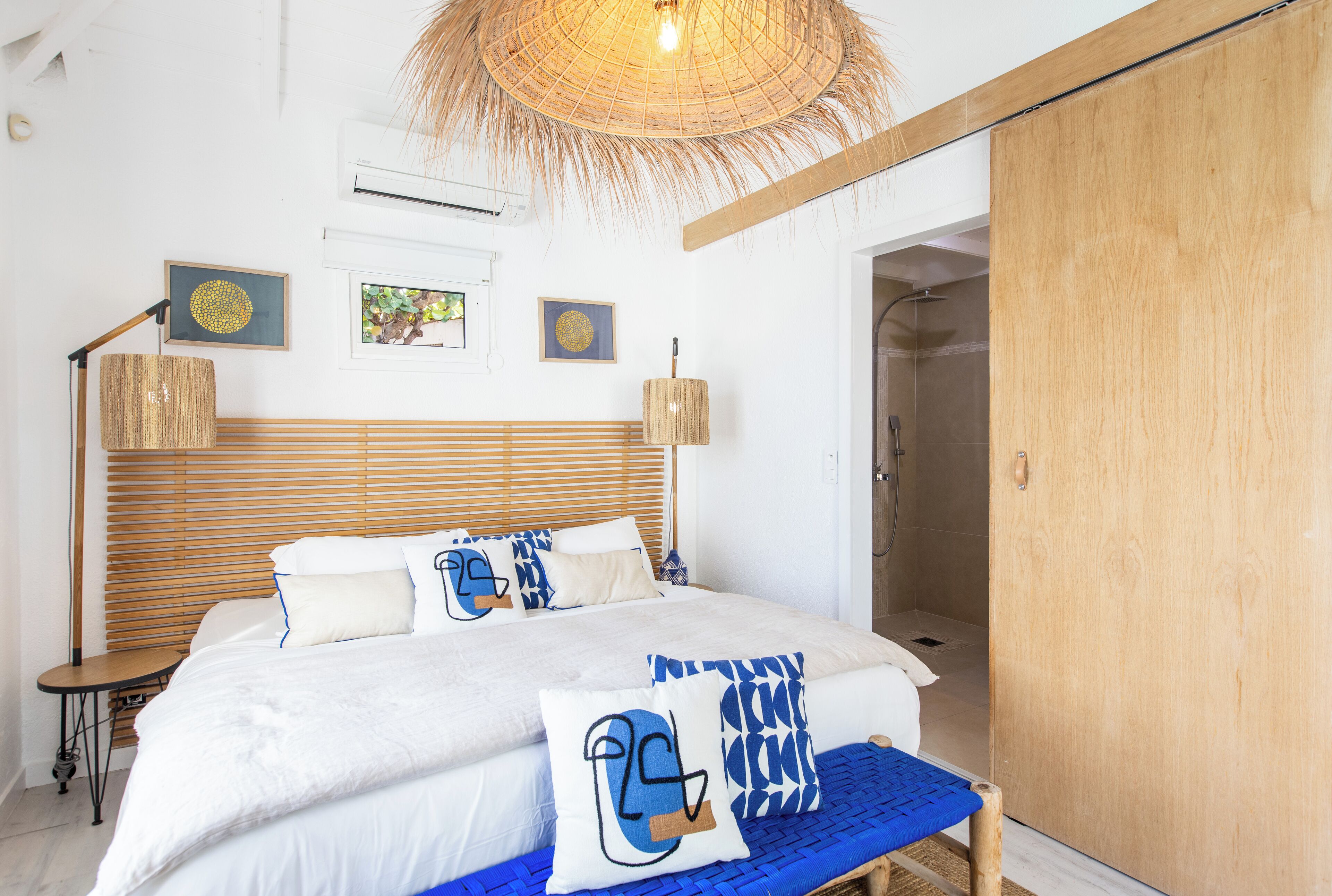 A bedroom with a large bed, a bedside table, a lamp, and a wardrobe.