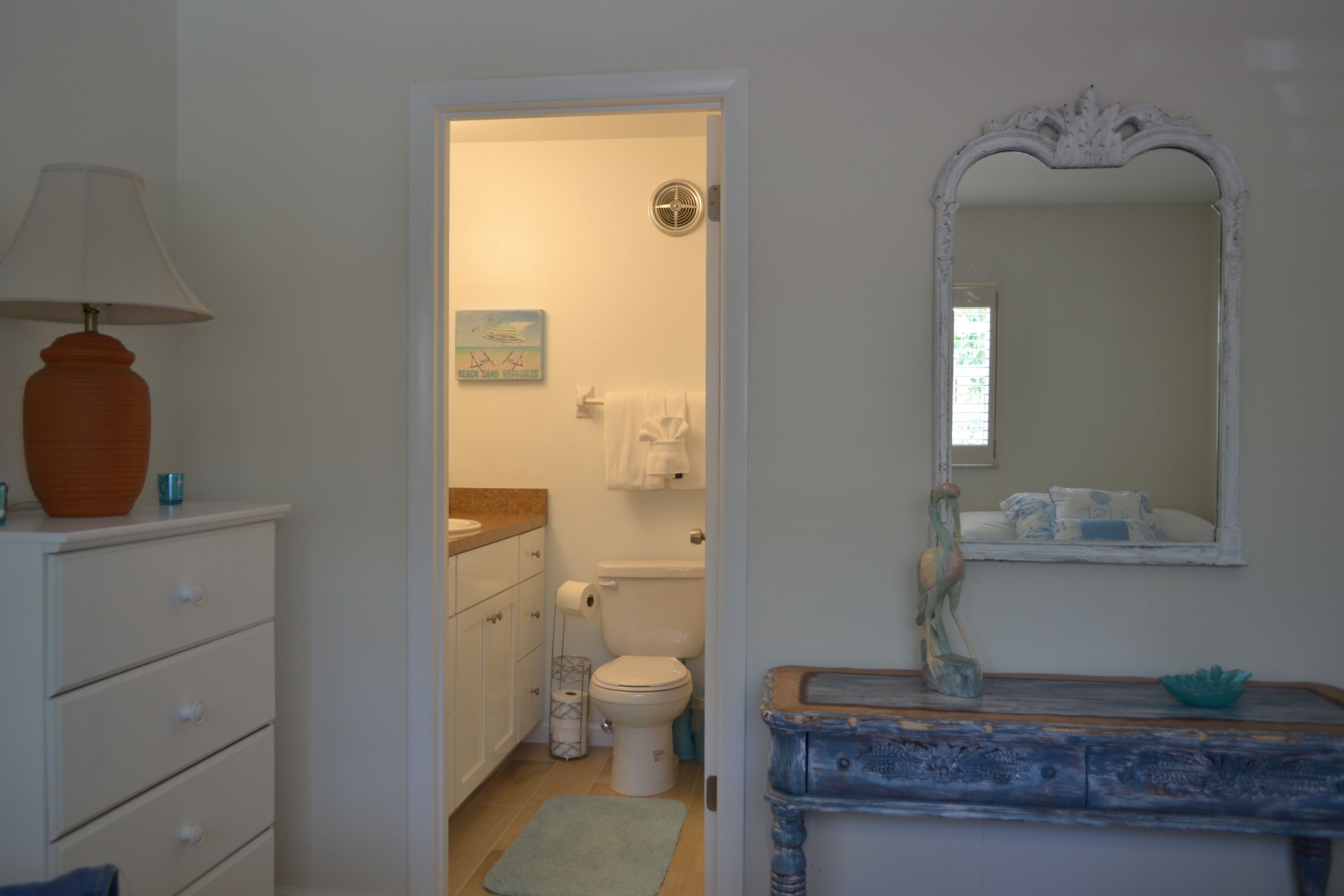 A bathroom with a white sink, a mirror, a towel rack, and a toilet.
