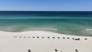 Ein Strand mit Reihen von Liegestühlen und freiem Blick auf das Meer.