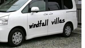 Un fourgon blanc avec l’inscription « Windfall Villas » sur le côté.