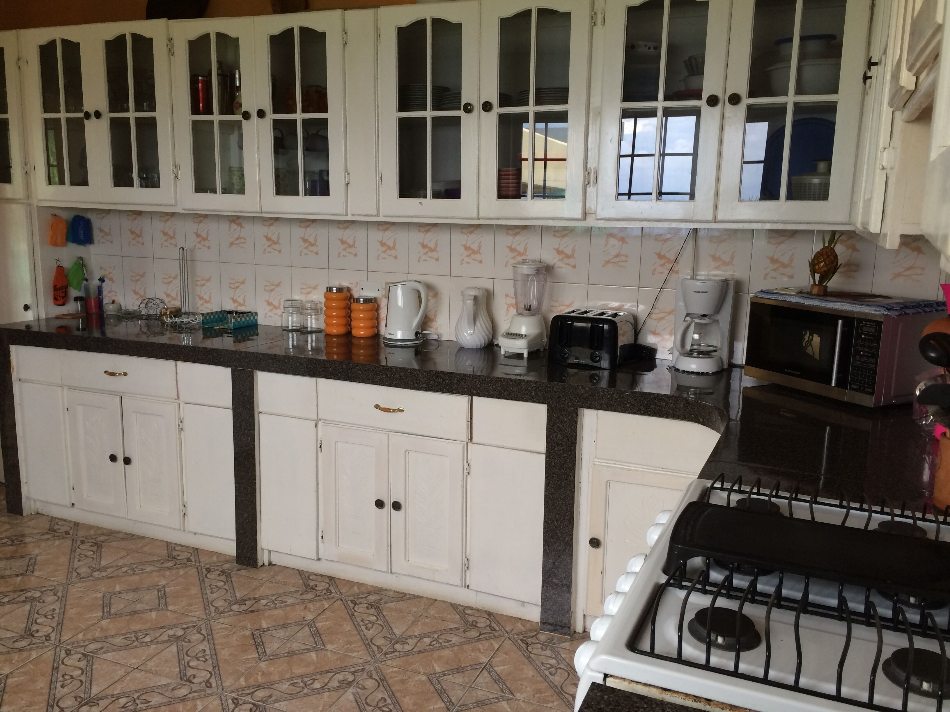 A kitchen with white cabinets, a granite countertop, and a gas stove.