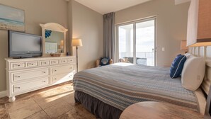 A bedroom with a large bed, a dresser, a television, and a balcony with a view. - Ocean Ritz 4 Bedroom 4 Bath**2 King Size beds*2 Masters on water!! (Panama City Beach)