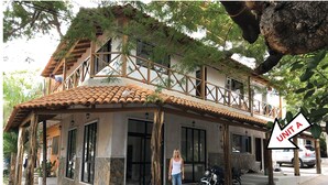 Un bâtiment à deux étages, doté d’un toit en tuiles, de murs en pierre et d’un balcon.