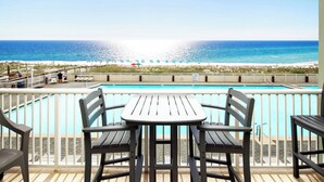 A poolside area with a view of the beach and ocean.