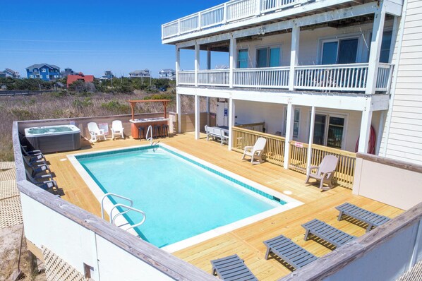 A pool area with lounge chairs, a hot tub, and a deck. - Semi-Oceanfront Rodanthe Home w/ Pool, Hot Tub, Elevator, Game and Media Rooms (Rodanthe)