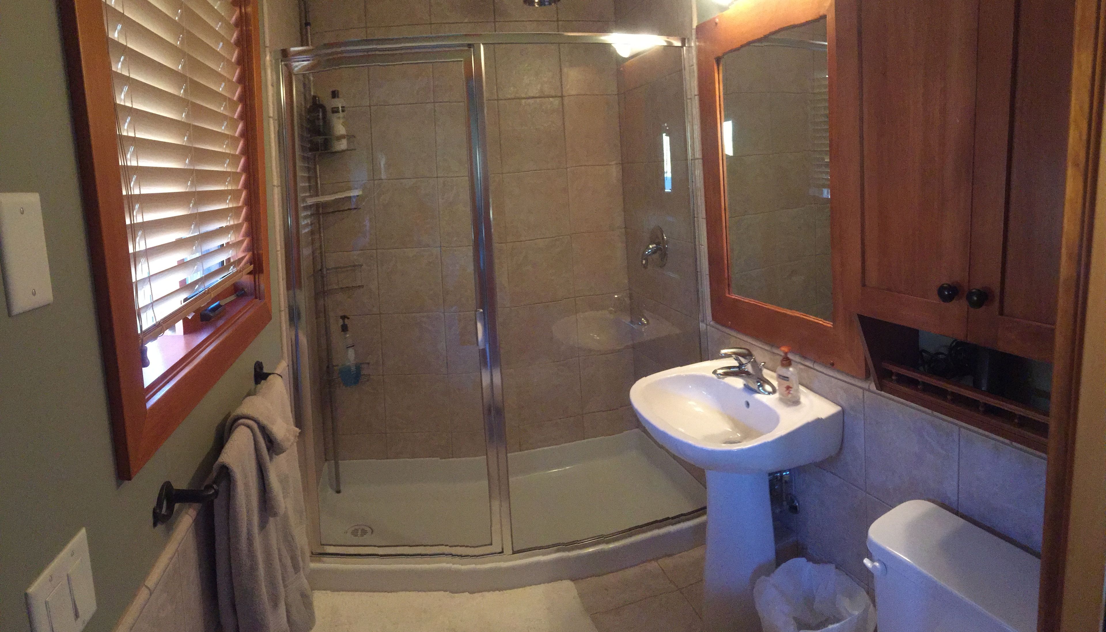 Een badkamer met een douchecabine, een wastafel en een toilet.